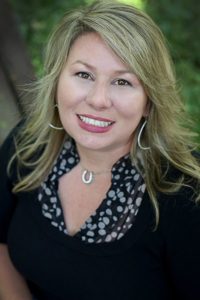 Realtor Kim Hock looking up at camera smiling in elegant black and white clothing